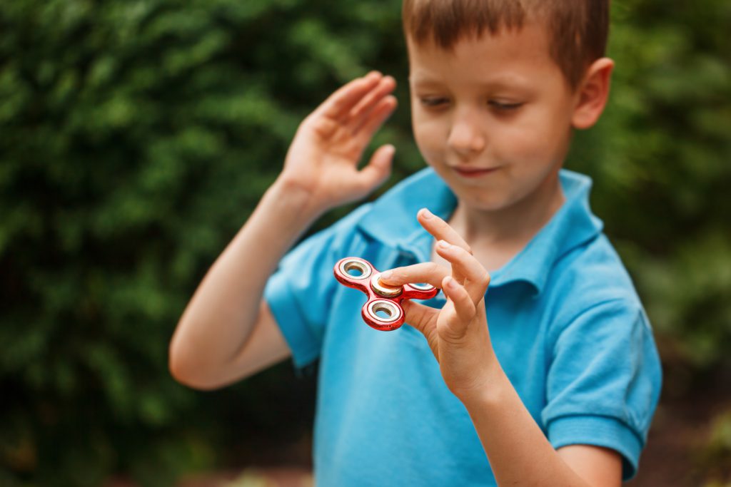 autistic child using fidget spinners for therapy 