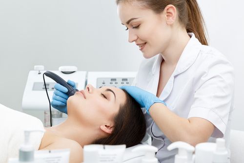 Woman getting electrolysis done in a female doctor's clinic.