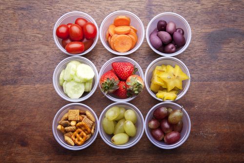 Fruits, vegetables and crackers in portion control bowls. 