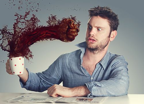 Shocked man being punched by morning coffee.
