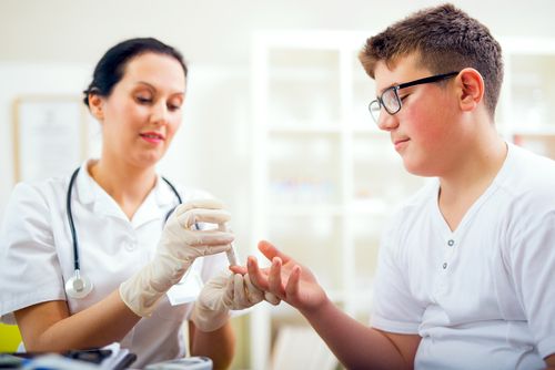 Doctor checking the blood sugar of a diabetic child. 