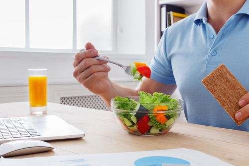 Man having a healthy salad with orange juice.