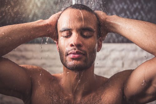 Handsome Afro American man showering. 