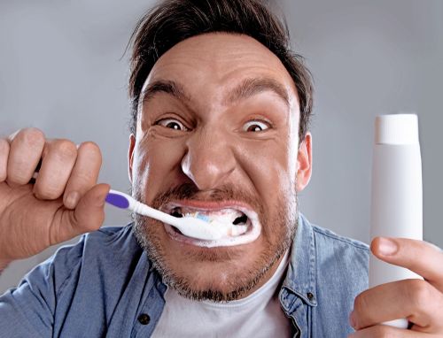 Man brushing his teeth aggressively. 