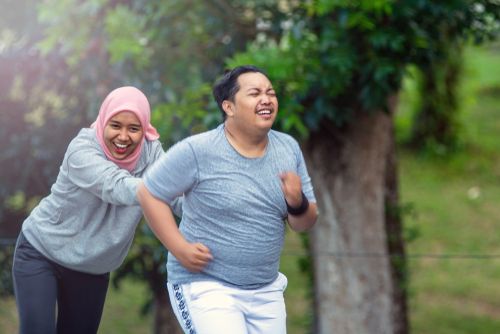 Hijabi woman running with her husband.