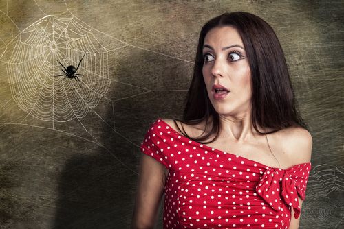 A woman in red clothes getting scared of spiders.