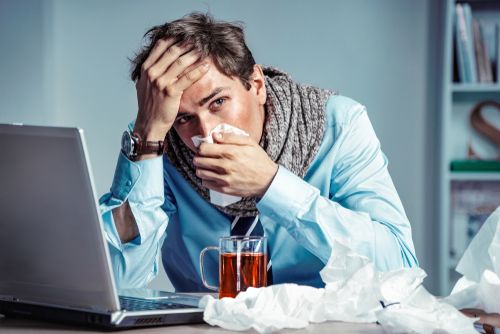 Stressed man working with a flu.